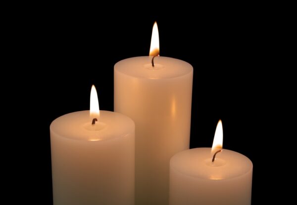Close,Up,Of,White,Candles,Burning,On,Black,Background. Luz en la oscuridad